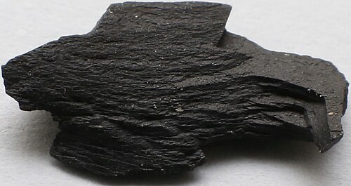 A hard black stone, polished and used in jewellery.
